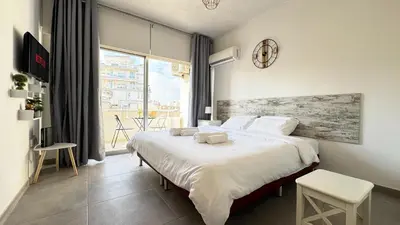 a bedroom with a large bed and a large window at Seaside Larnaca Makenzie- 50m to Beach in Larnaka