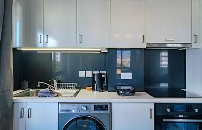 a kitchen with a washing machine and a sink at Element Stays City Suite in Nicosia