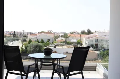 a table and chairs on a balcony with a view at Modern 2BR near UNIC & Engomi Mall in Lakatamia