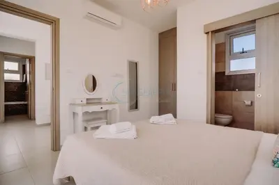 a white bedroom with a bed and a sink at Alasia 16 - Modern smart villa in tranquil serenity in Paralimni