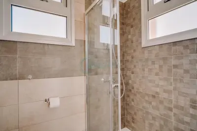 a bathroom with a glass shower stall and windows at Alasia 16 - Modern smart villa in tranquil serenity in Paralimni