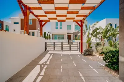 a patio with a wooden pergola in front of a house at Alasia 16 - Modern smart villa in tranquil serenity in Paralimni