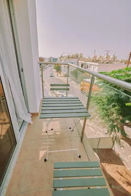 a balcony with green benches and a view of a street at Rosam Seaview Holiday apartment in Ayia Napa