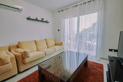 a living room with a couch and a glass table at Rosam Seaview Holiday apartment in Ayia Napa