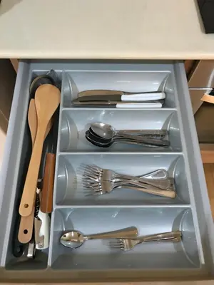 a drawer filled with silver utensils in a cabinet at Ithaki Phinikoudes Apartment No. 107 in Larnaka