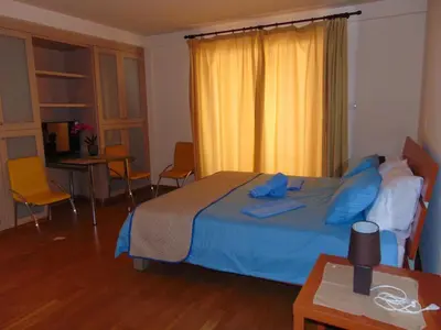 a bedroom with a bed with blue pillows on it at Ithaki Phinikoudes Apartment No. 107 in Larnaka