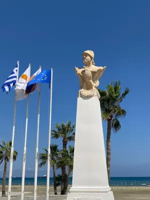 a statue on the beach next to some flags at Ithaki Phinikoudes Apartment No. 207 in Larnaka