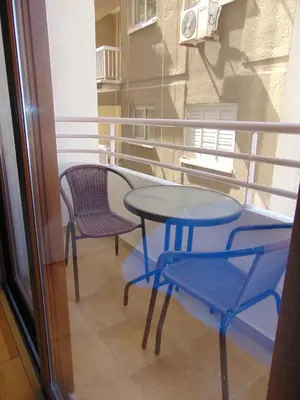 a balcony with two chairs and a table and chairs at Ithaki Phinikoudes Apartment No. 207 in Larnaka