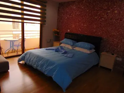 a bedroom with a bed with blue sheets and blue pillows at Ithaki Phinikoudes Apartment No. 207 in Larnaka