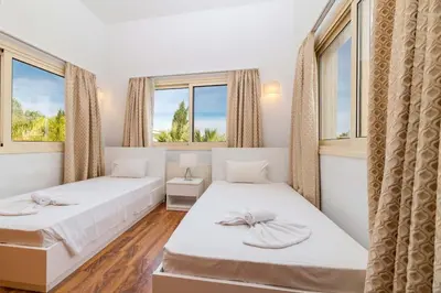 two beds in a room with two windows at Anthorina Greco Villa #18 in Protaras