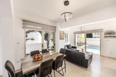 a dining room and living room with a table and chairs at villa Palms 31 in Protaras