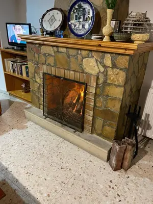 a stone fireplace with a clock on top of it at Omodos Village Houses in Omodos