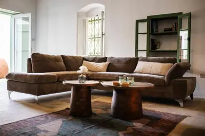 a living room with a brown couch and two tables at Eftychia's House in Lofou