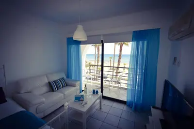 a living room with a couch and a view of the beach at Krasas Beach Apartment Rentals in Larnaka
