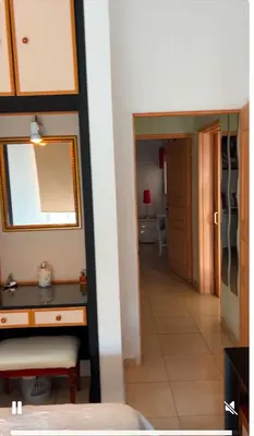 a bedroom with a desk and a mirror and a hallway at Bar street apartment in Ayia Napa