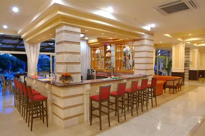 a bar in a restaurant with red stools at Anesis Hotel in Ayia Napa