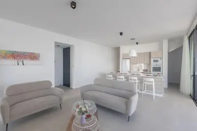 a living room with two couches and a kitchen at Protaras Aqua Pearl Villa in Protaras