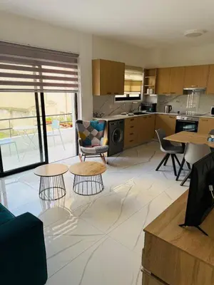 a living room with two tables and a kitchen at Brand new, Finikoudes area in Larnaka
