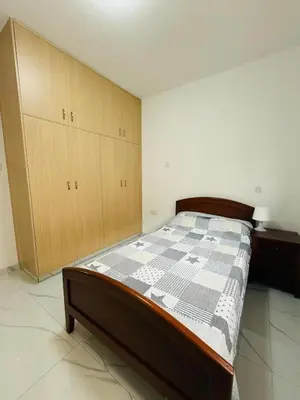 a bedroom with a bed and wooden cabinets at Brand new, Finikoudes area in Larnaka
