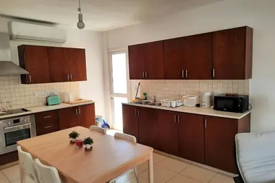 a kitchen with wooden cabinets and a wooden table at Center, Walking to the Beach in Larnaka