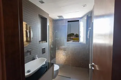 a bathroom with a sink and a toilet and a mirror at Sea Satin Villas - Ayia Napa Center in Ayia Napa