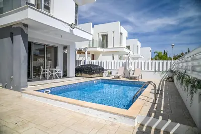 a villa with a swimming pool in front of a house at Hi royal villa in Pervolia