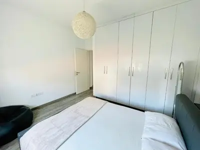 a bedroom with a bed and white cabinets at LimassolStar Etko Area in Limassol