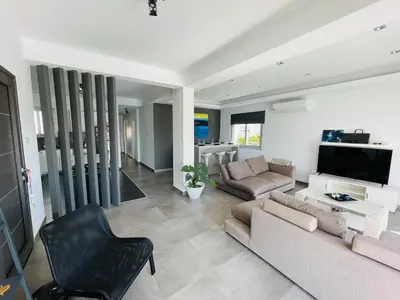 a living room with a couch and a tv at LimassolStar Etko Area in Limassol