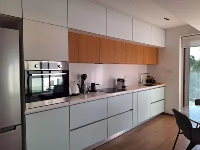 a kitchen with white appliances and wooden cabinets at Luxury Seafront 2 bedroom in Limassol
