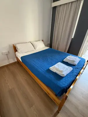 a bed with blue sheets and white towels on it at D Pitsillos Homes luxury in Larnaka