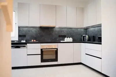 a white kitchen with white cabinets and appliances at Delightful 1st Floor Xanthippis Apartment in Strovolos