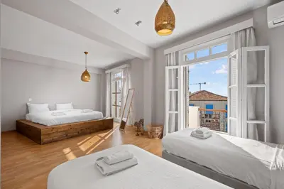 a bedroom with two beds and a large window at St Lazar Penthouse Apartment in Larnaka