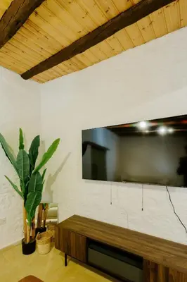 a living room with a large flat screen tv on a wall at Rustic Elegance in Omodos in Omodos