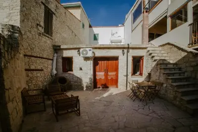 an alley with a building with a red door at Rustic Elegance in Omodos in Omodos
