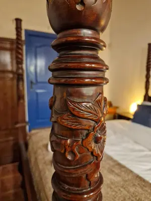 a wooden post of a bed in a bedroom at The Courtyard Suite in Limassol