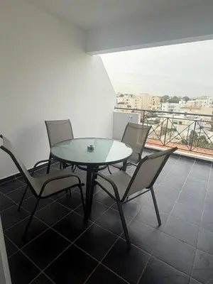 a table and chairs in a room with a balcony at Elegant 2BR Apartment- La Vie Royale in Nicosia