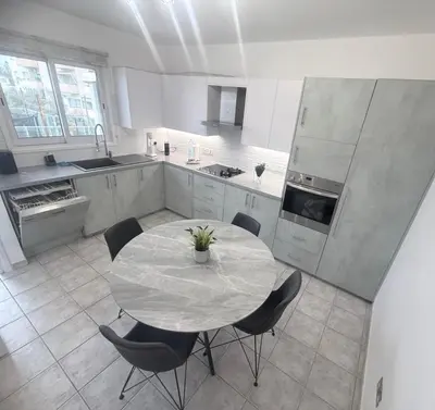 a large kitchen with a table and chairs in it at Elegant 2BR Apartment- La Vie Royale in Nicosia