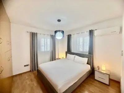a bedroom with a large white bed and windows at Elegant 2BR Apartment- La Vie Royale in Nicosia