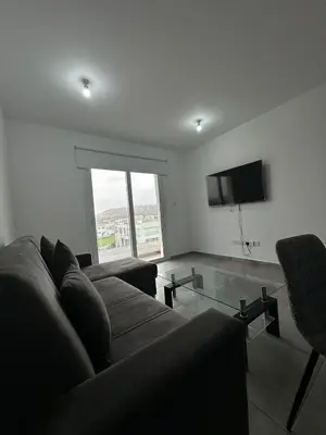 a living room with a couch and a glass table at Oroklini's Flat in Larnaka