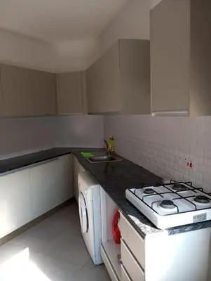 a white kitchen with a stove and a sink at FLAT Ceremi in Nicosia
