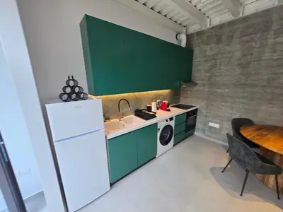 a kitchen with green cabinets and a sink and a table at Green Leaf - Old City Suite in Limassol