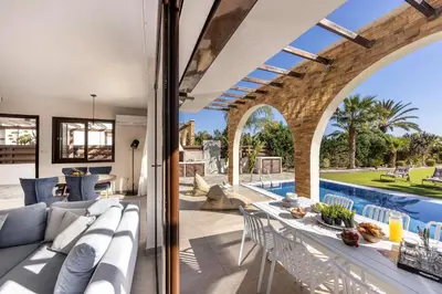 a living room with a couch and a table and a pool at Ayia Napa Seafront Ionion Villa H5 in Ayia Napa