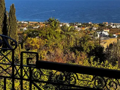 a view of the ocean from a balcony at A historic STONE VILLA with private garden, terrace and private pool just for you in Kérynia