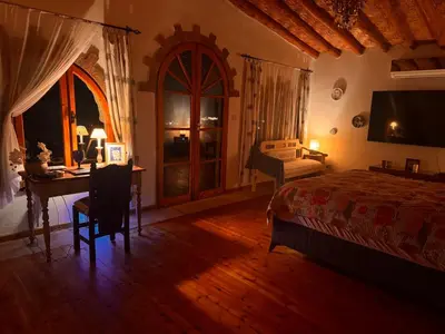 a bedroom with a bed and a desk and a table at A historic STONE VILLA with private garden, terrace and private pool just for you in Kérynia