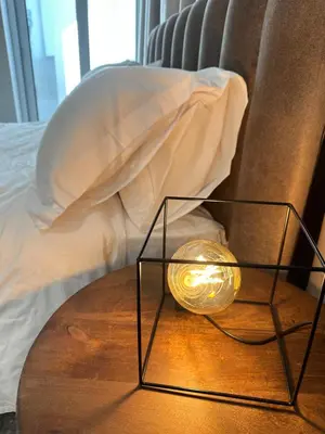 a lamp on a table next to a bed at Aurora Downtown Living in Nicosia