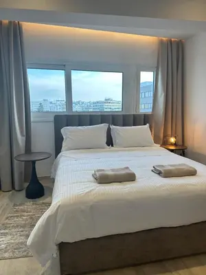 a bedroom with a large bed with two towels on it at Aurora Downtown Living in Nicosia