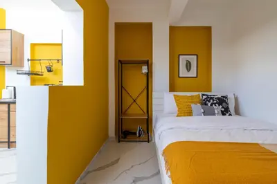 a bedroom with yellow walls and a bed at The Pop Art Residences & Studios in Larnaca in Larnaka