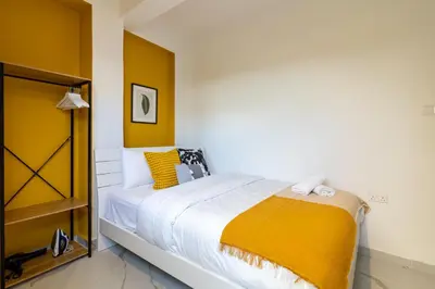 a bedroom with a large bed with yellow walls at The Pop Art Residences & Studios in Larnaca in Larnaka