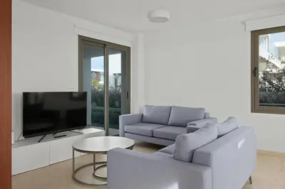 a living room with a couch and a tv at Serenity Waves Villa 5 in Larnaka