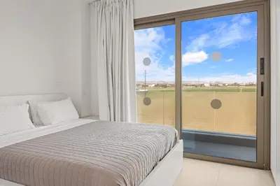 a bedroom with a bed and a large window at Serenity Waves Villa 11 in Larnaka